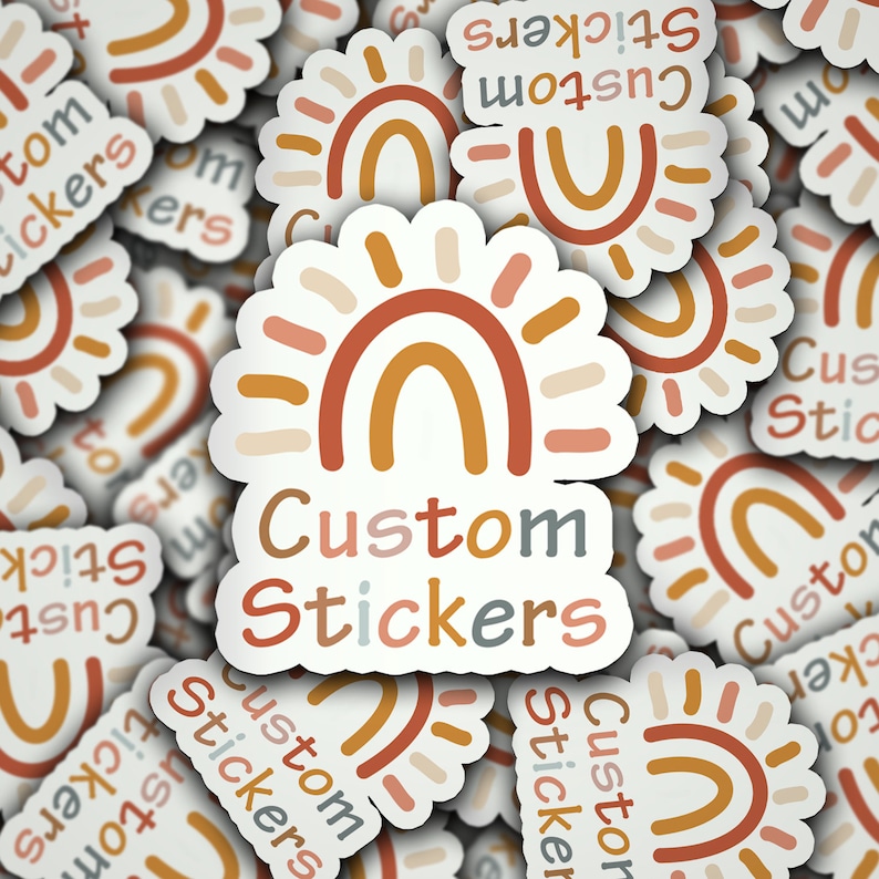 May include: A collection of custom stickers with a boho rainbow design. The stickers feature a white background with a sunburst design in shades of orange, brown, and peach. The text "Custom Stickers" is printed in a mix of colors.