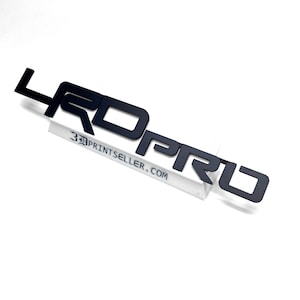 May include: Black 3D printed "4Runner PRO" logo. The logo is made of a durable material and is perfect for adding a custom touch to your vehicle.