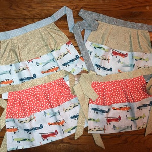 Pilots on Alert !!  Great tiny planes fly patterns on the bottom pocket of this adorable apron