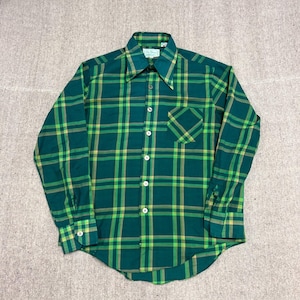 May include: Green plaid shirt with long sleeves and a chest pocket. The shirt has a classic collar and white buttons. The plaid pattern incorporates shades of green and yellow.