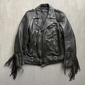 May include: A black leather motorcycle jacket featuring long fringe detailing on the sleeves, a quilted interior lining, silver-tone metal zips, snap-button lapels, and adjustable side buckles at the waist for a secure fit and classic aesthetic.