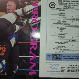 May include: A vintage WWF wrestling program cover featuring a wrestler in a blue and white outfit lifting another wrestler. The program lists the event details for November 21, 1993, at the Hartford Civic Center.