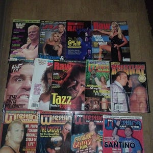 May include: A collection of vintage wrestling magazines featuring various wrestlers on the covers. The magazines have colorful covers with text and images, showcasing the sport's stars and events.