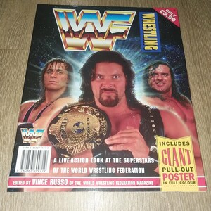May include: A vintage wrestling magazine featuring three wrestlers, one holding a championship belt. The cover has the WWF logo and the word "Wrestling". The magazine includes a giant pull-out poster.