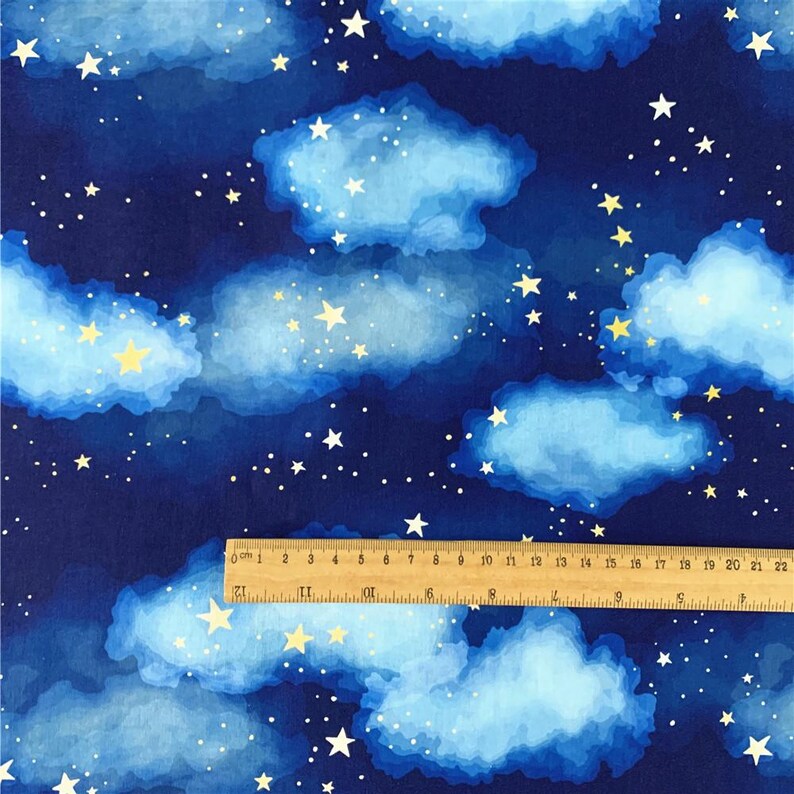 Op de afbeelding: Een blauwe stof met een aquarelontwerp van witte wolken en gele sterren. De stof heeft een herhalend patroon.