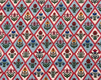 May include: A repeating pattern of stylized floral designs in red, yellow, blue, and green on a light blue background. The floral designs are arranged in a diamond pattern.