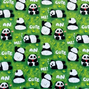 May include: A green fabric with a repeating pattern of black and white pandas. The pandas are in various poses, including sitting, standing, and lying down. The fabric also features the words "cute", "an", and "hi!" in white.