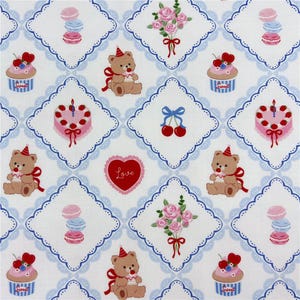May include: A repeating pattern on white fabric featuring various illustrations. These include teddy bears with party hats, cupcakes, cakes, macarons, cherries, roses, and a heart with the word "Love". The design is framed by a blue scalloped border.