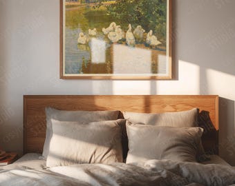 May include: A framed artwork depicting a group of white ducks in a pond, with a lush green background. The artwork is mounted above a bed with neutral-toned bedding and pillows. The room is bathed in natural light.