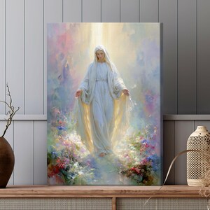 May include: Canvas art print of a serene figure in a flowing white gown, arms outstretched, set against a soft, ethereal backdrop of pastel colors and light. The artwork is surrounded by colorful flowers, creating a peaceful and spiritual scene.