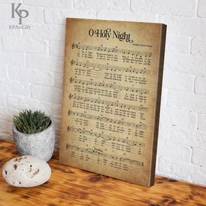 May include: Vintage sheet music print of the Christmas carol "O Holy Night" by Adolphe Adam. The music notes and lyrics are printed on a beige background with a distressed, aged look.