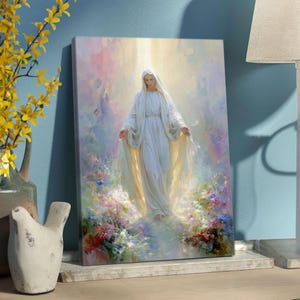 May include: A canvas print of a religious figure in a white gown with a flowing veil, surrounded by soft light and colorful flowers. The artwork has a serene and ethereal quality, with a focus on the central figure.