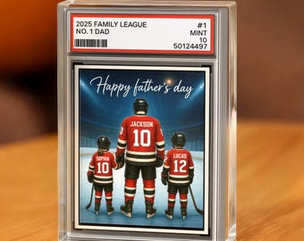 Puede incluir: Impresión enmarcada con temática de hockey. La impresión presenta a un padre y dos hijos con camisetas de hockey con el texto "Happy father's day". La parte superior del marco dice "2025 FAMILY LEAGUE NO. 1 DAD".