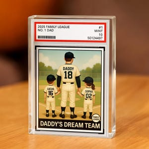 May include: A baseball card encased in a clear holder. The card features a family of four on a baseball field. The text on the card reads "2025 Family League No. 1 Dad" and "Daddy's Dream Team."