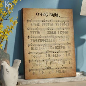 May include: A vintage-style print of the sheet music for the Christmas carol "O Holy Night". The music is printed on a cream-colored background with brown ink. The title "O Holy Night" is printed in large, bold letters at the top of the page. The lyrics and music notes are printed below the title.