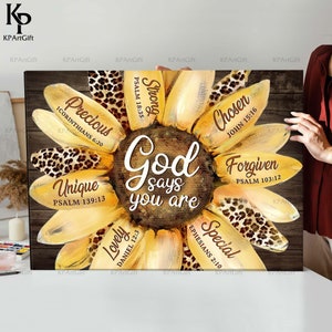 May include: A yellow sunflower with brown spots on the petals. The center of the sunflower has the words "God says you are" written in brown. Each petal has a word and a bible verse written on it. The words are "Precious", "Strong", "Chosen", "Forgiven", "Unique", "Lovely", and "Special".