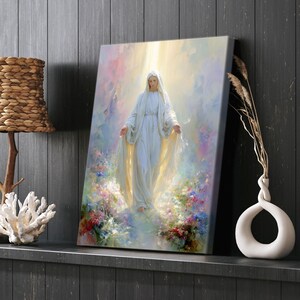 May include: A canvas print depicts a serene figure in a flowing white gown, arms outstretched, amidst a soft, colorful background of flowers and light. The artwork evokes a sense of peace and spirituality, suitable for home decor.