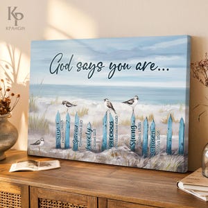 May include: A blue and white canvas print with a beach scene and a wooden fence with signs that say "God says you are..." and list different words like "unique", "special", "lovely", "precious", "strong", and "chosen" with bible verses underneath each word.