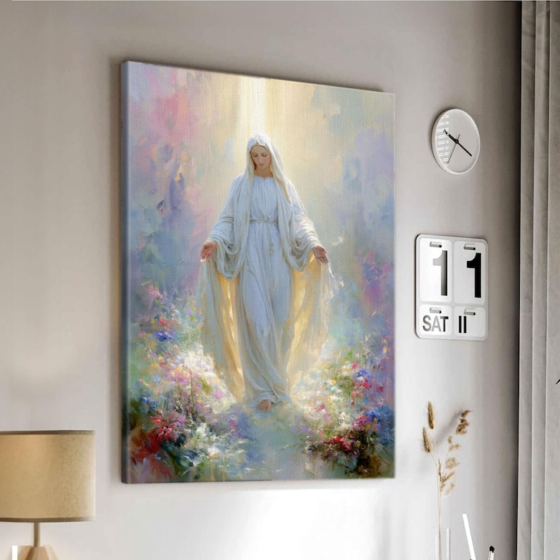 May include: A canvas print depicting a figure in a white gown with a flowing veil, surrounded by soft light and colorful flowers. The artwork has a serene and spiritual theme, suitable for home decor.