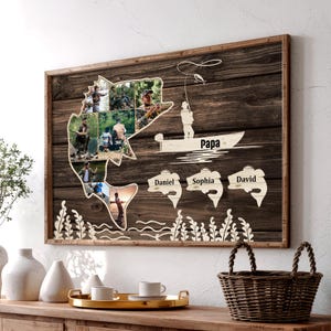 May include: A framed wooden wall art piece with a rustic design. The artwork features a fish-shaped cutout filled with photos, a fisherman in a boat, and the word "Papa." Names Daniel, Sophia, and David are also included.