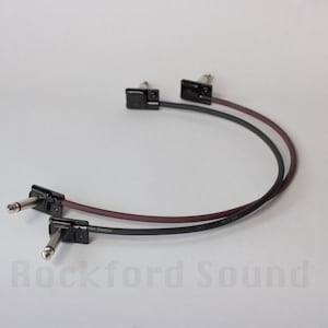 May include: Two black guitar patch cables with right-angle plugs. One cable is black and the other is burgundy.