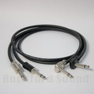 May include: Two black 1/4 inch guitar cables with right angle plugs. One cable has a straight plug on the other end, the other cable has a right angle plug on the other end.