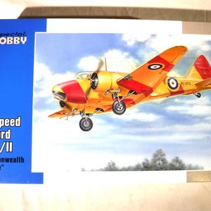 May include: A model kit box for an Airspeed Oxford Mk.I/II Commonwealth Service by Special Hobby in 1/48 scale. The box features an illustration of a yellow and red twin-engine aircraft in flight against a blue sky with white clouds.