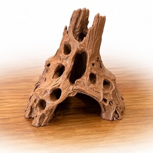 May include: A brown, hollow, tree-stump-shaped object with a textured, weathered surface featuring multiple irregular openings and holes throughout its structure, resembling a piece of driftwood or a natural forest element for decorative use.