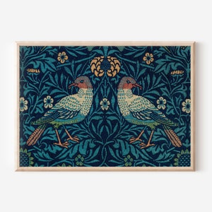May include: A framed print of a vintage textile design featuring two blue birds with orange beaks and a repeating pattern of blue, green, and yellow flowers and leaves.