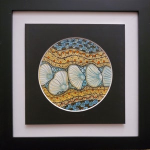 May include: A framed circular artwork with a blue, yellow, and white design. The artwork features a series of white shapes resembling shells or flowers, surrounded by intricate patterns in shades of blue, yellow, and orange.
