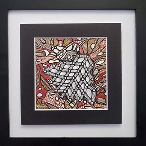 May include: Framed abstract art print with a black and white geometric design on a red, brown, and white background. The artist's signature is visible in the bottom left corner.