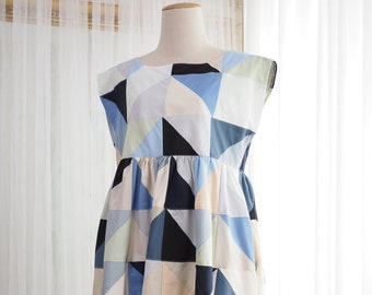 May include: A sleeveless dress with a geometric pattern in shades of blue, black, white, and beige. The dress has a fitted bodice and a full skirt.