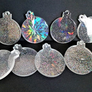 May include: Eight clear round baubles with silver glitter. Some baubles have a holographic design.
