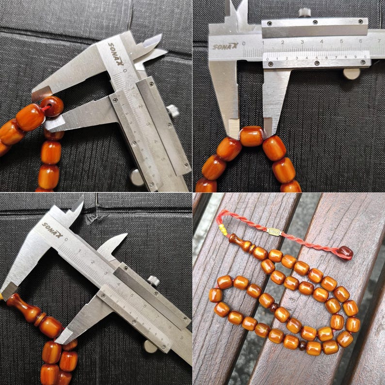 Op de afbeelding: Een set amberkleurige houten gebedskralen met een rode kwast. De kralen worden gemeten met een schuifmaat, wat aangeeft dat de grootte van elke kraal ongeveer 3,8 cm in diameter is.