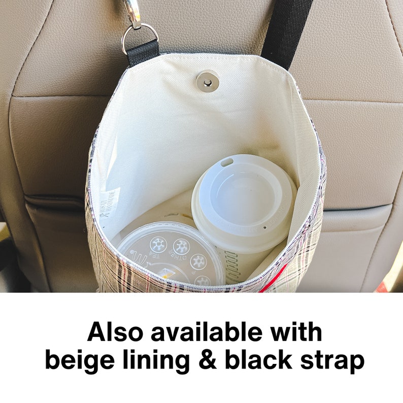 May include: A plaid car trash can with a black strap and a white interior. The can is hanging on the back of a car seat and contains a white coffee cup and a clear container.