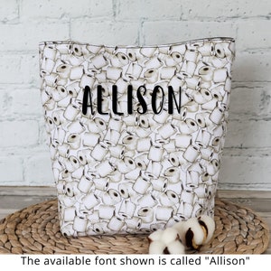 Peut inclure: Sac fourre-tout en toile blanche avec un imprim&eacute; de rouleaux de papier toilette et le nom "Allison" en texte noir.