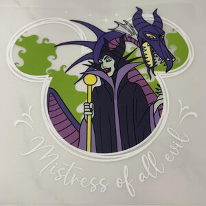 May include: A graphic decal featuring a character in a black and purple robe holding a yellow staff, positioned in front of a purple dragon head and green smoke. The design is framed by a white Mickey Mouse ear outline with the text Mistress of all evil.