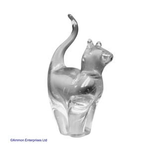 May include: A clear glass cat figurine with a curled tail. The figurine is made of clear glass and has a smooth, polished finish.