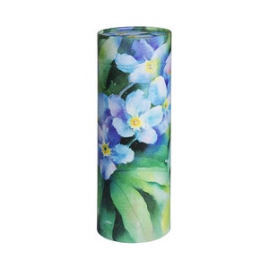 Op de afbeelding: Een cilindrische crematie urn met een aquarel ontwerp van blauwe vergeet-mij-nietjes en groene bladeren.