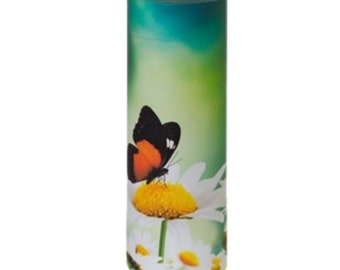 Puede incluir: Una urna de cremación cilíndrica verde y blanca con un diseño de mariposa sobre una margarita.