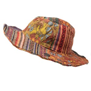 May include: A wide-brimmed, multi-coloured hat with a floral and geometric pattern. The hat is made of a woven fabric and has a flat top.
