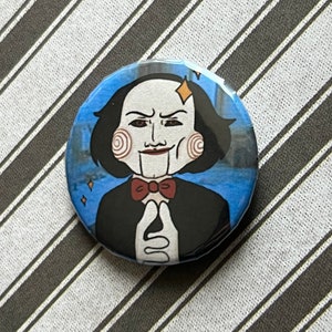 Könnte beinhalten: Ein runder Button mit einer Cartoon-Illustration eines puppenartigen Charakters mit weißer Haut, schwarzem Haar und einer roten Fliege. Die Figur ist vor einem blauen Hintergrund mit Stadtbild und Glitzer dargestellt.
