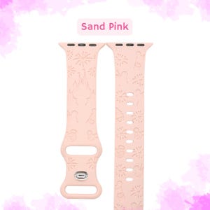 May include: Sand pink Apple Watch band with a Disney theme. The band features a pattern of fireworks, Mickey Mouse, Cinderella's castle, and other Disney icons.
