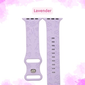 May include: A lavender silicone Apple Watch band with a Disney theme. The band features a pattern of fireworks, Mickey Mouse, Cinderella's castle, and other Disney icons.