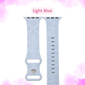 May include: Light blue Apple Watch band with a white Disney print featuring Mickey Mouse, fireworks, and Cinderella's castle.
