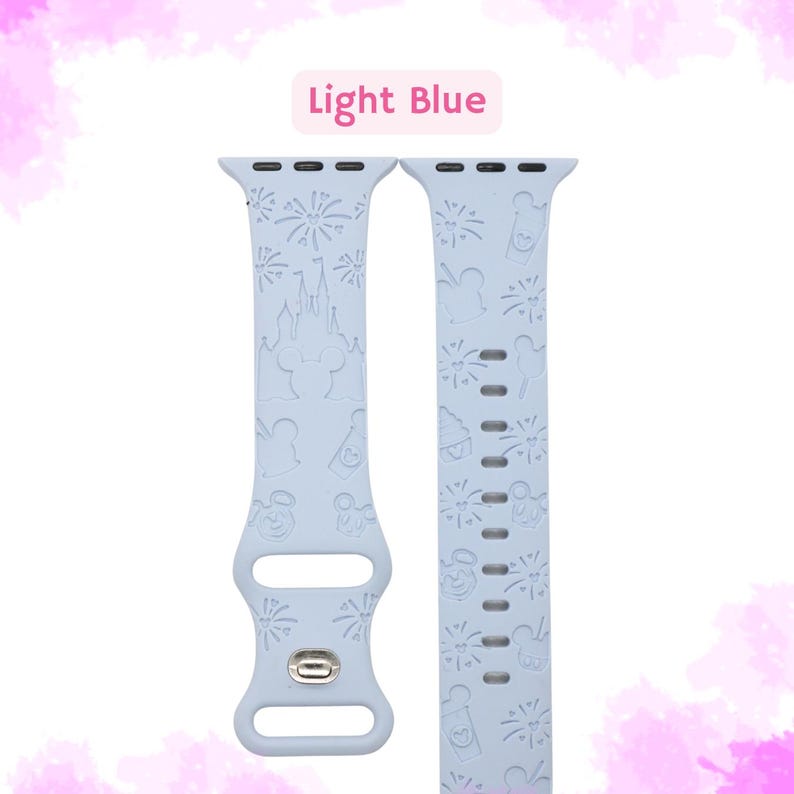 May include: Light blue Apple Watch band with a white Disney print featuring Mickey Mouse, fireworks, and Cinderella's castle.