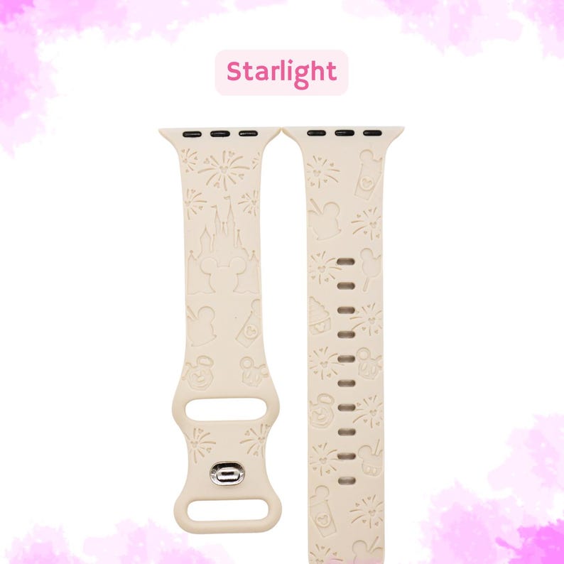 May include: A cream-colored silicone Apple Watch band with a white embossed design featuring Mickey Mouse, fireworks, and Cinderella's castle. The band is labeled "Starlight".