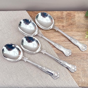 Peut inclure: Un ensemble de trois cuillères en métal argenté poli avec un bol arrondi et un manche décoratif orné d'un motif de coquille en relief à l'extrémité. Les cuillères présentent une surface réfléchissante et un motif détaillé sur la tige.