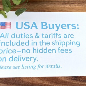 May include: A white rectangular sign featuring a small American flag icon and light blue text that reads: USA Buyers: All duties & tariffs are included in the shipping price&mdash;no hidden fees on delivery. Please see listing for details.