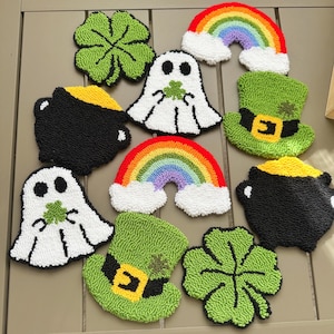 May include: Nine colorful felt crafts with a St. Patrick's Day theme. The crafts include a rainbow, a pot of gold, a four-leaf clover, a leprechaun's hat, and a ghost holding a four-leaf clover.
